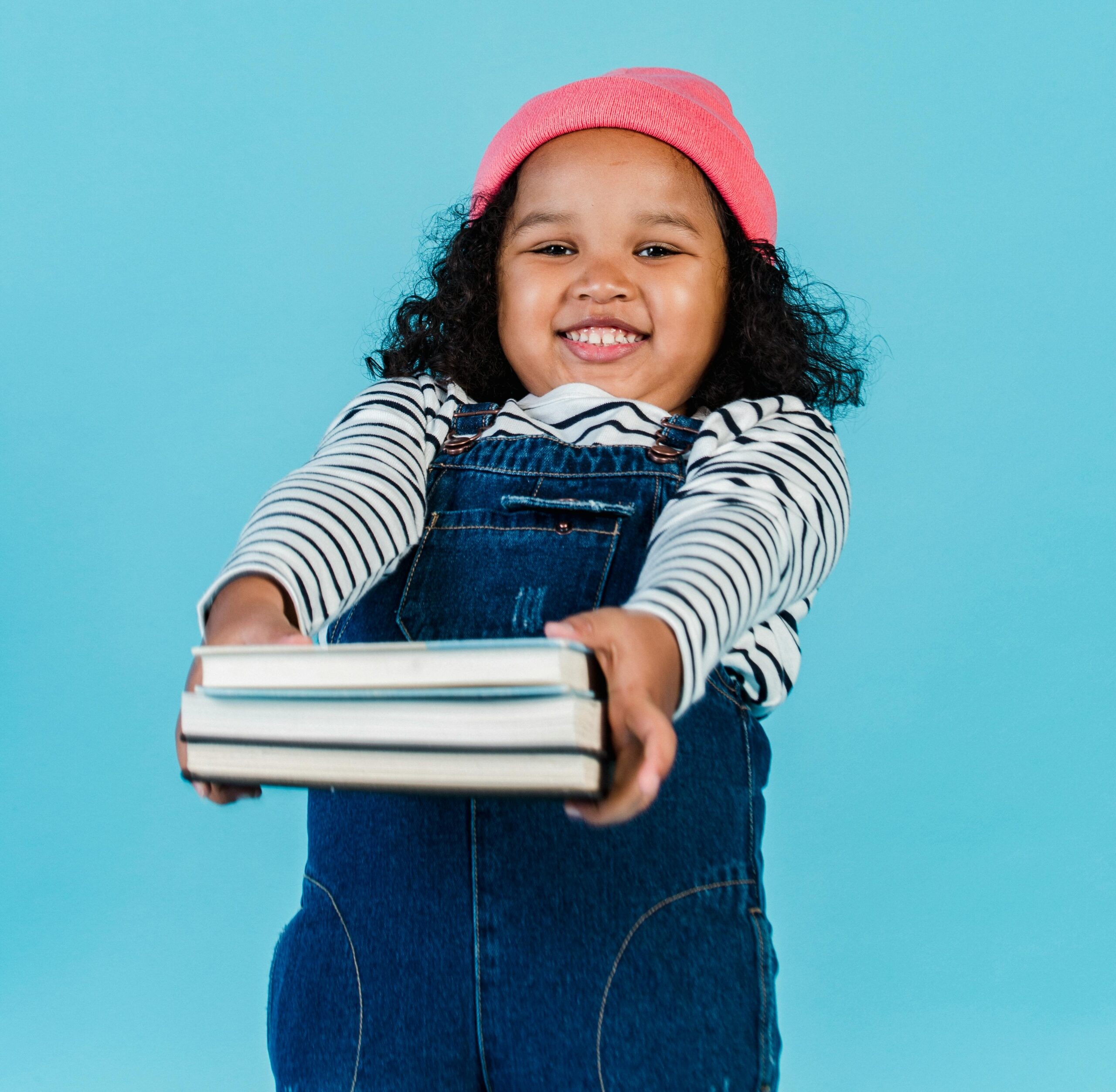 Mädchen mit Schulbücher vor blauem Hintergrund