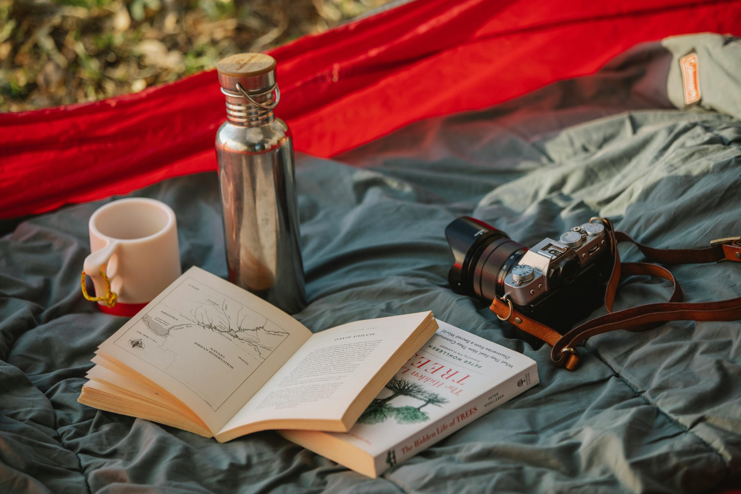 Edelstahltrinkflasche auf Decke, neben Bücher