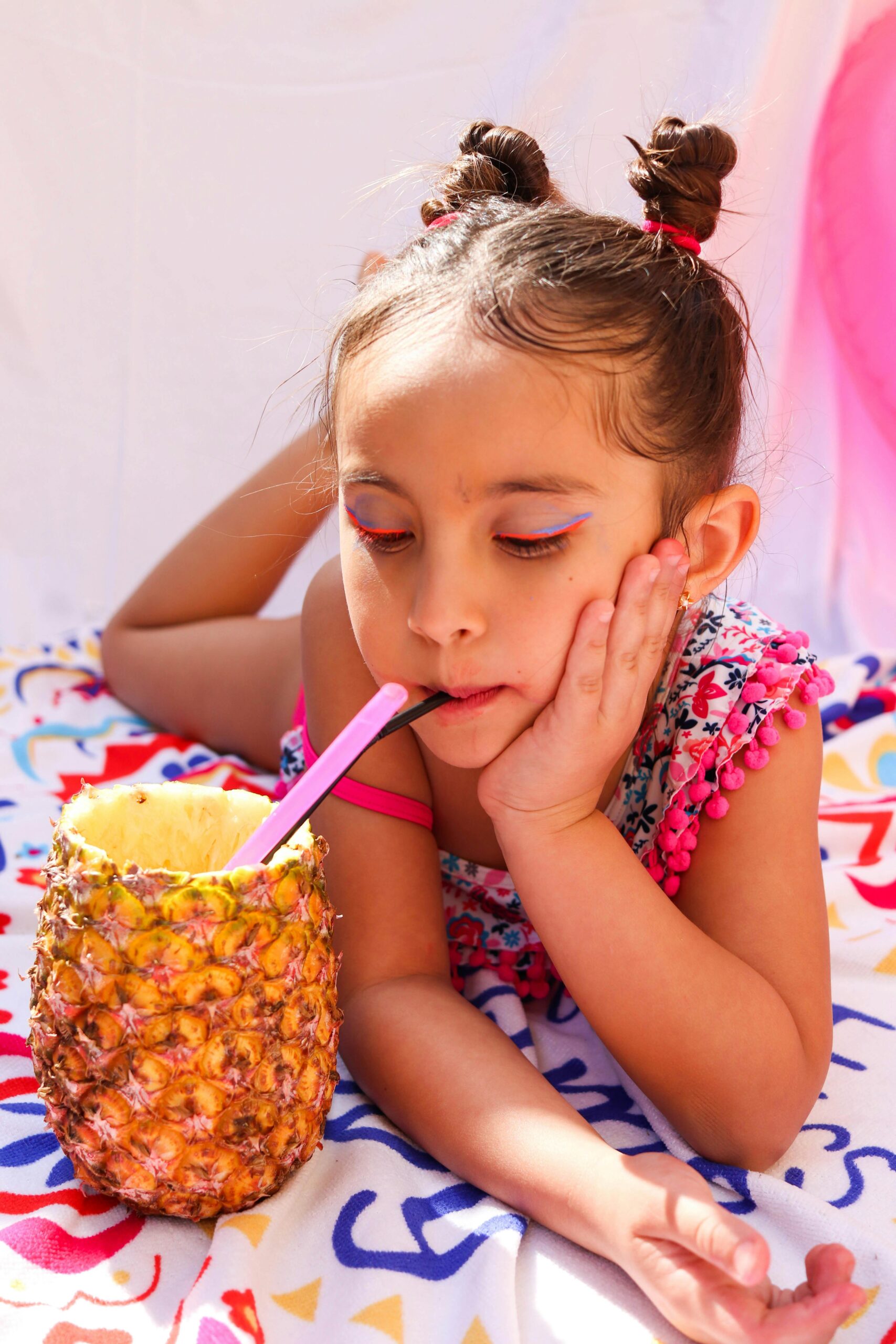 Kind trinkt aus einer Ananas mit einem Strohhalm