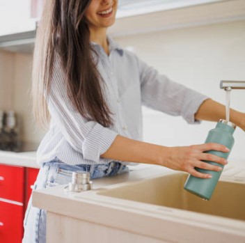 Frau reinigt Trinkflasche